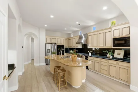 a kitchen with stainless steel appliances kitchen island granite countertop a sink and cabinets