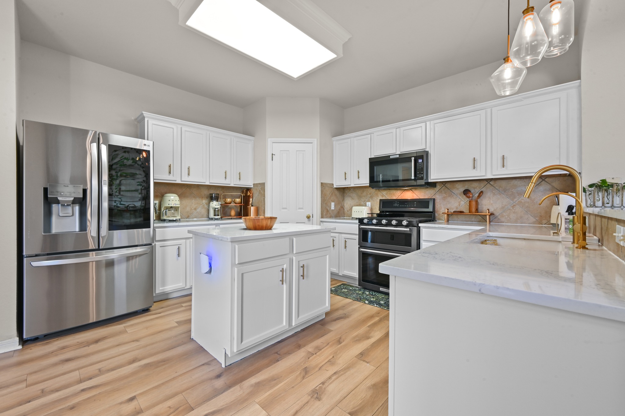 5888 Fergus Kyle, TX 78640 - Photo 9 of 40 Culinary aspirations come alive in this kitchen featuring abundant white cabinetry and an inviting island centerpiece.