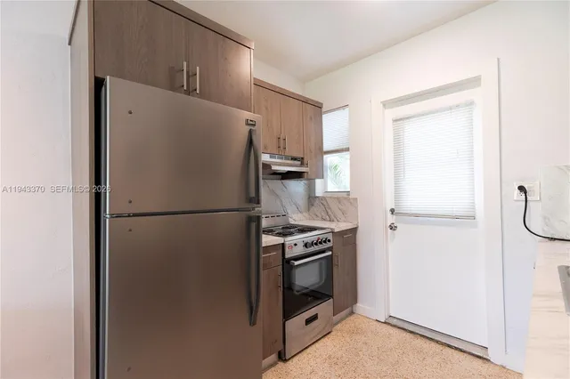 a white refrigerator freezer and a stove sitting inside of a kitchen