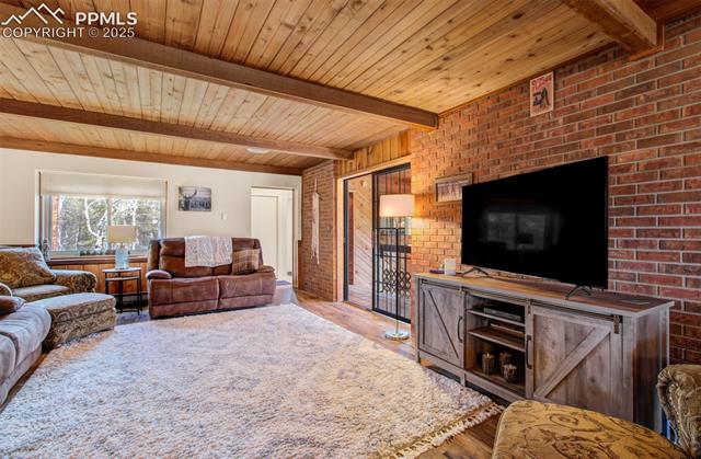 749 Aspen Village Road Divide, CO 80814 - Photo 10 of 49 Wood ceilings with beams and a rustic brick wall