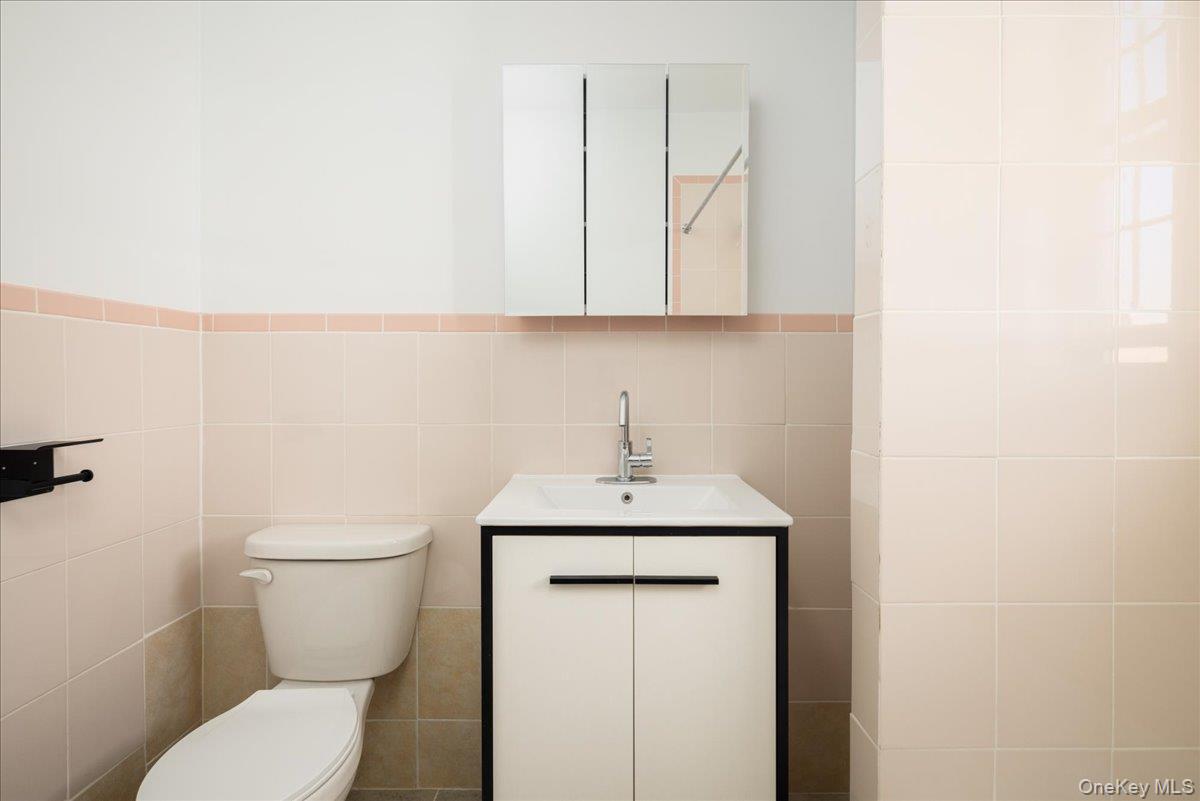 83-09 Talbot, Unit 6L Queens, NY 11415 - Photo 5 of 19 a bathroom with a toilet a sink and a mirror