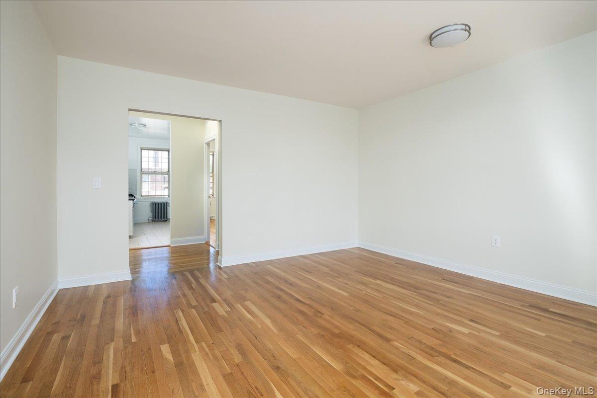 83-09 Talbot, Unit 6L Queens, NY 11415 - Photo 10 of 19 a view of empty room with wooden floor and fan