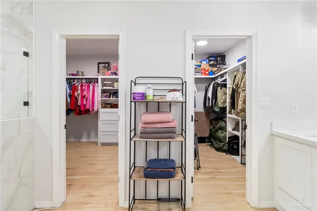 a view of walk in closet with clothes