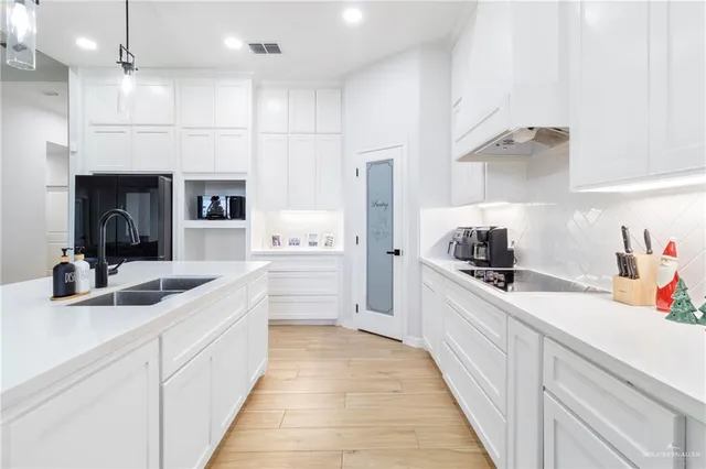 a kitchen with kitchen island white cabinets and white appliances