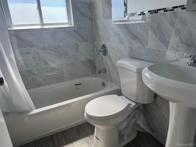 a white toilet sitting next to a bath tub
