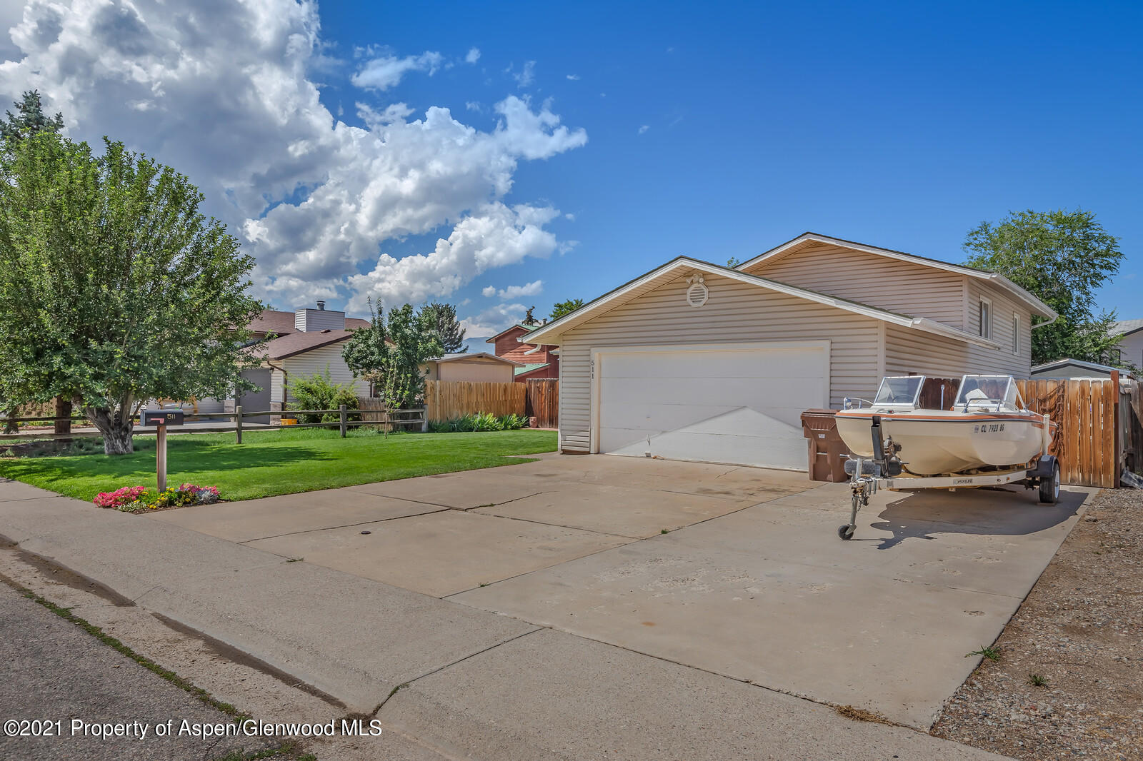 511 Fairway Avenue Rifle, CO 81650 - Photo 3 of 17 a white house with a yard and wooden fence