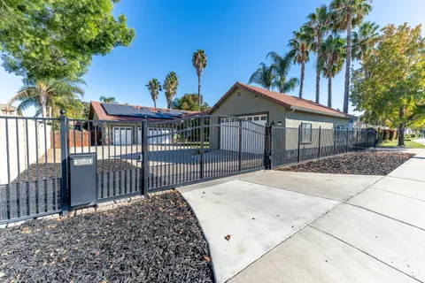 a view of a house with a small yard and wooden fence