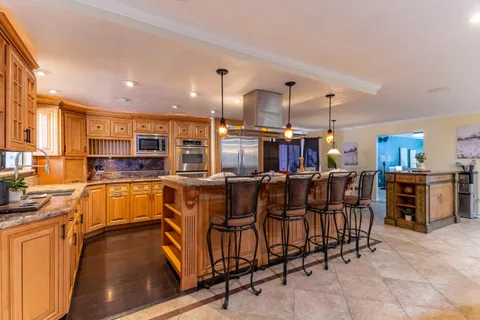 a kitchen with stainless steel appliances granite countertop a refrigerator and a stove