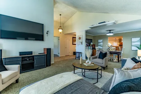 a living room with furniture a flat screen tv and a fireplace