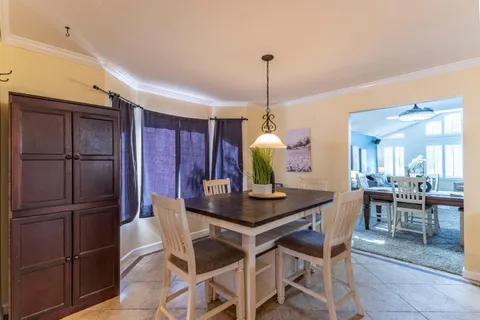 a aerial view of a house with a yard and table and chairs under an umbrella