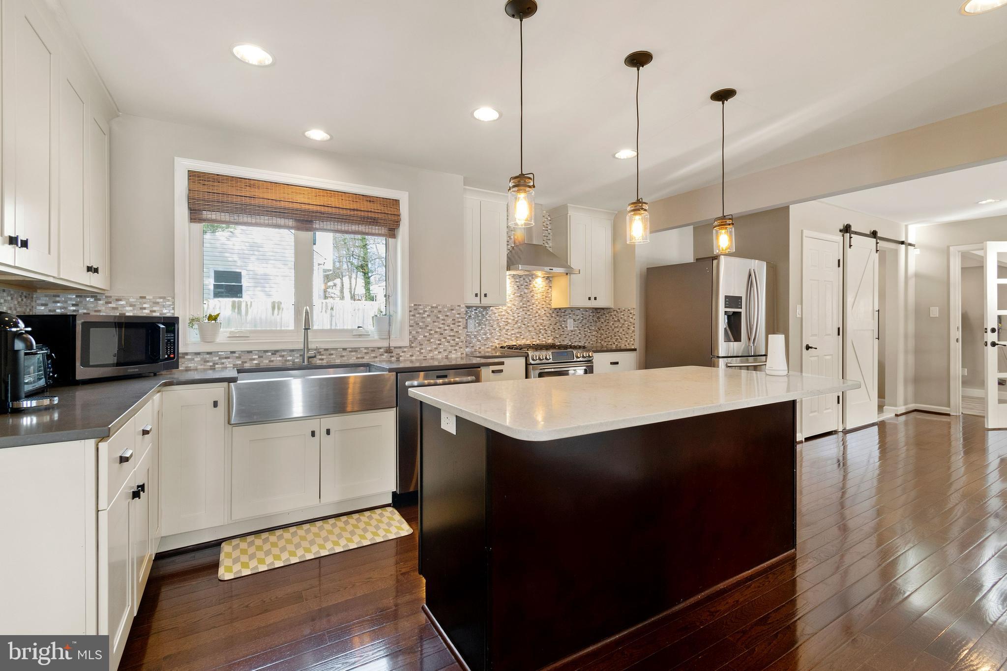 11600 Coldstream Drive Potomac, MD 20854 - Photo 10 of 25 a kitchen with stainless steel appliances granite countertop a sink a stove a refrigerator and island with wooden floor