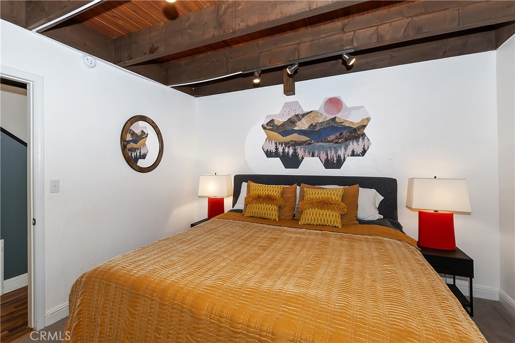 42533 Moonridge Road Big Bear Lake, CA 92315 - Photo 15 of 37 a bedroom with a bed and a chandelier