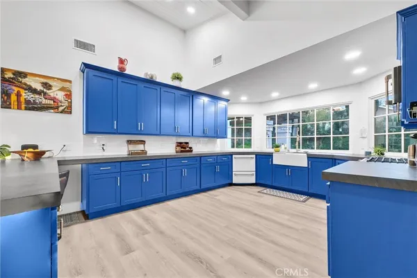 a kitchen with stainless steel appliances kitchen island granite countertop wooden cabinets a stove a sink and a island