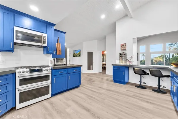 a kitchen with stainless steel appliances granite countertop a stove and a wooden floors