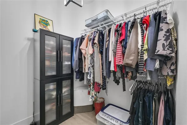 a view of walk in closet with clothes and shoes
