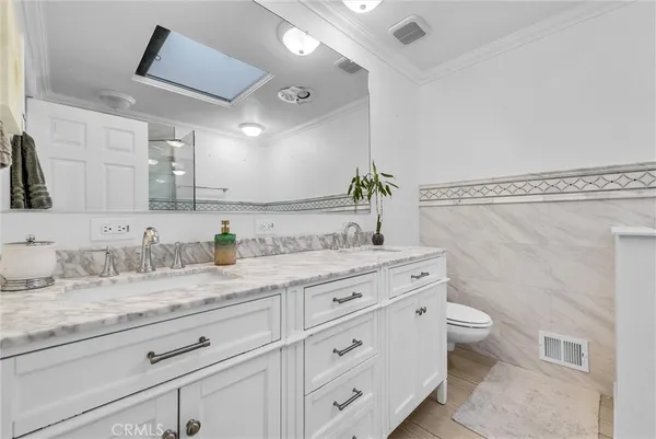 a bathroom with a granite countertop sink a toilet and a mirror