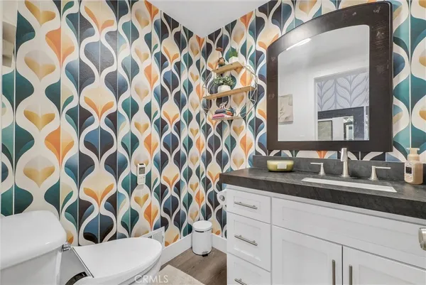 a bathroom with a granite countertop sink a toilet and a mirror