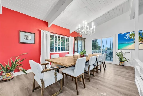 a view of a dining room with furniture a chandelier and wooden floor