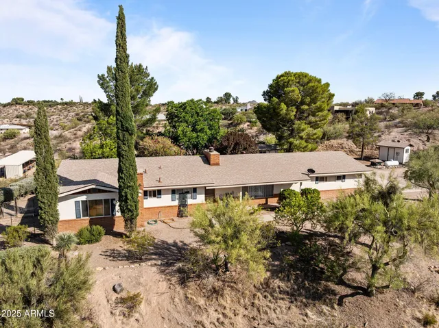 an aerial view of a house with a yard and large tree