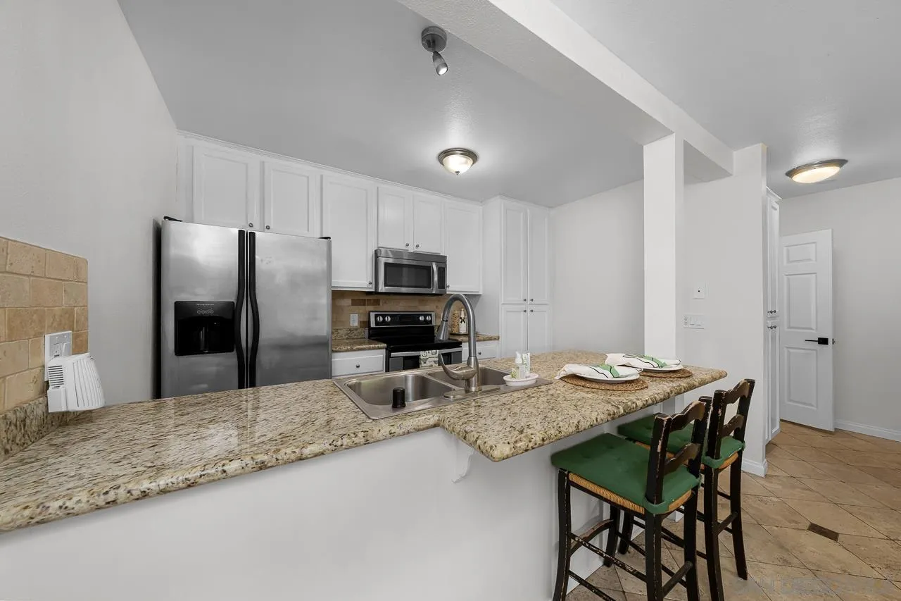 9860 Dale Avenue, Unit C3 Spring Valley, CA 91977 - Photo 6 of 26 a kitchen with stainless steel appliances granite countertop a sink refrigerator stove and microwave