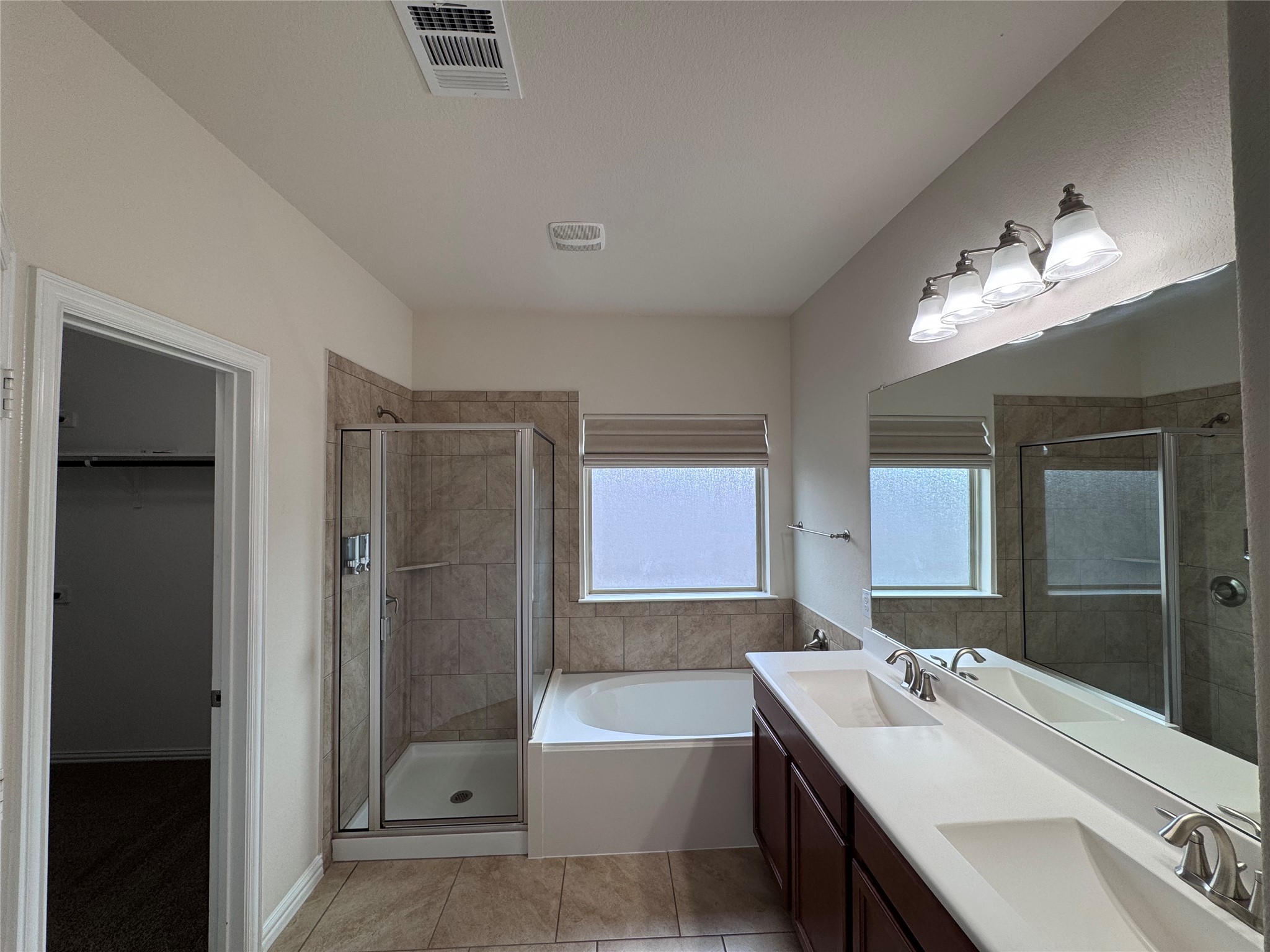 2605 Rough Berry Road Pflugerville, TX 78660 - Photo 34 of 40 Dual vanities and a spacious shower offer luxurious convenience in this bathroom retreat.