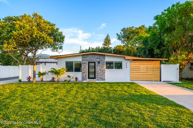 a view of a house with patio and a garden