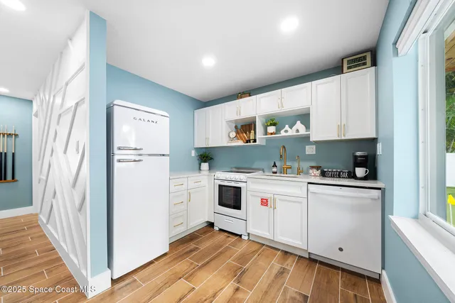 a kitchen with white cabinets and white appliances