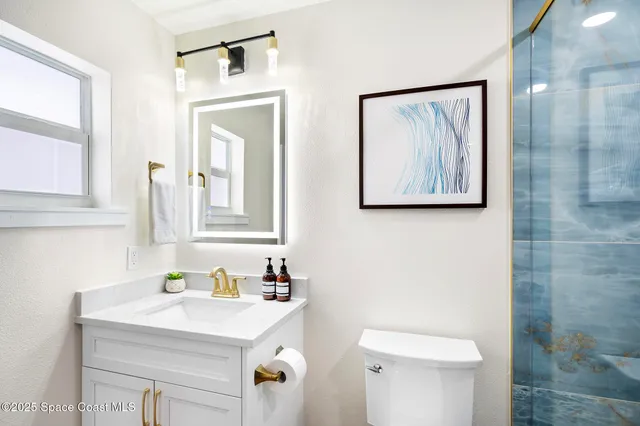 a bathroom with a sink mirror and toilet