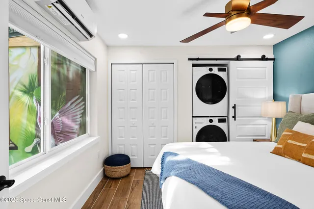 a bedroom with a bed a clock and a large window