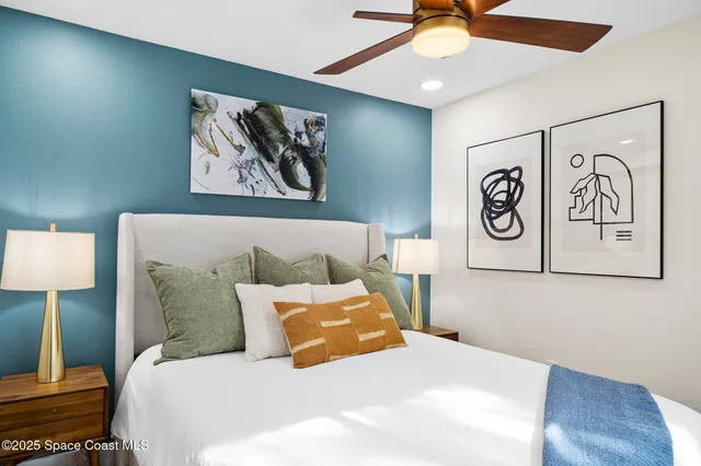 a bedroom with a bed and a lamp on dresser