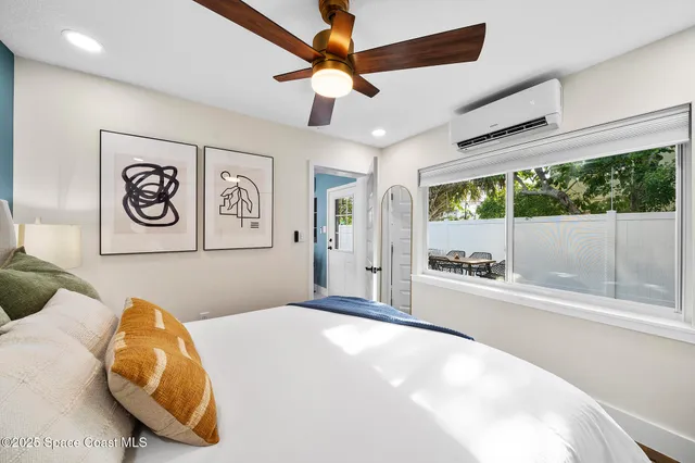 a bedroom with a bed and a large window