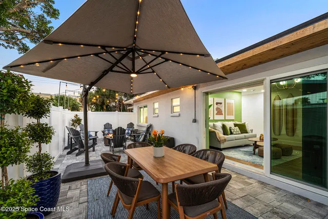 a view of a patio with table and chairs under an umbrella
