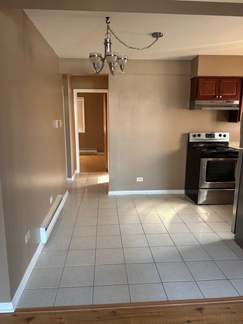 6323 West 64th Place, Unit 1D Chicago, IL 60638 - Photo 4 of 16 a view of a kitchen with a sink and a stove top oven