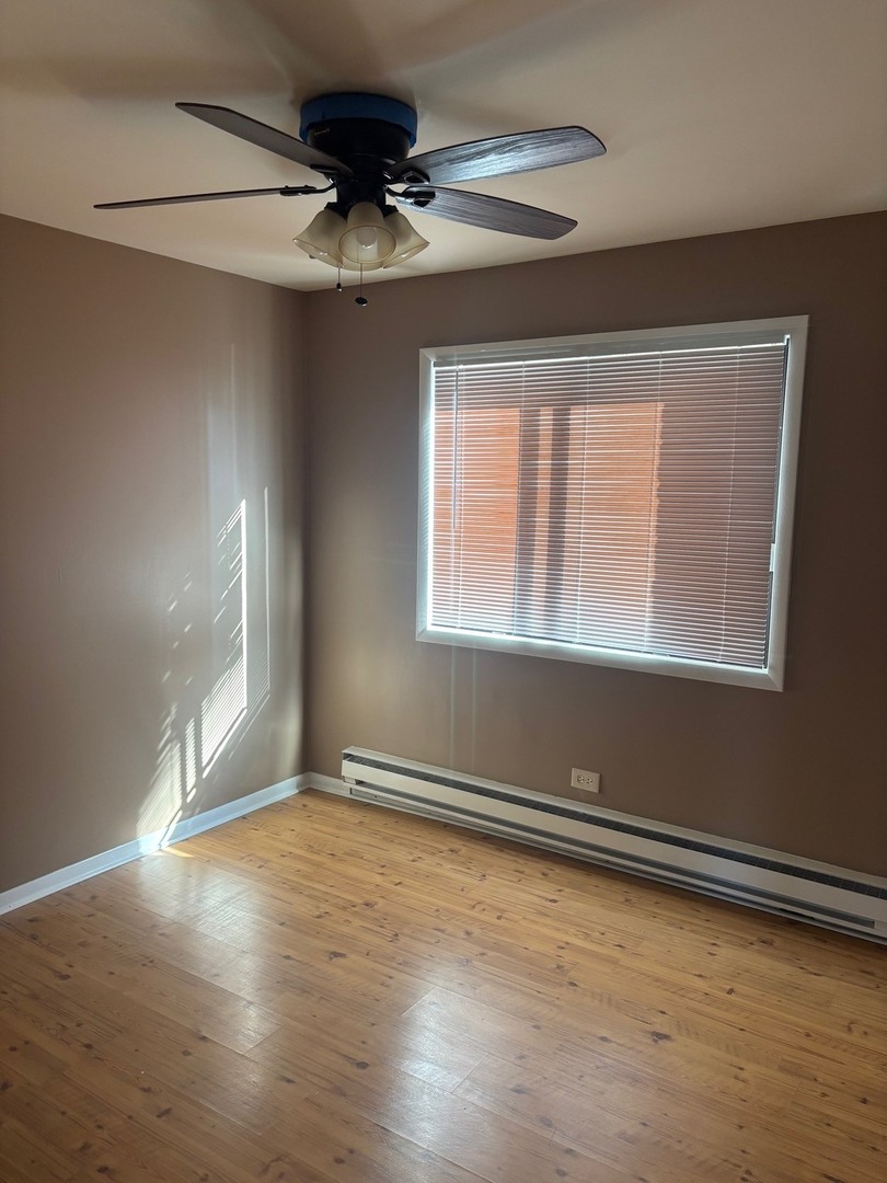 6323 West 64th Place, Unit 1D Chicago, IL 60638 - Photo 8 of 16 a view of an empty room with wooden floor and a window