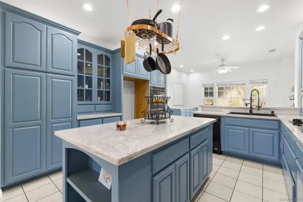 a kitchen with kitchen island granite countertop a stove and a sink