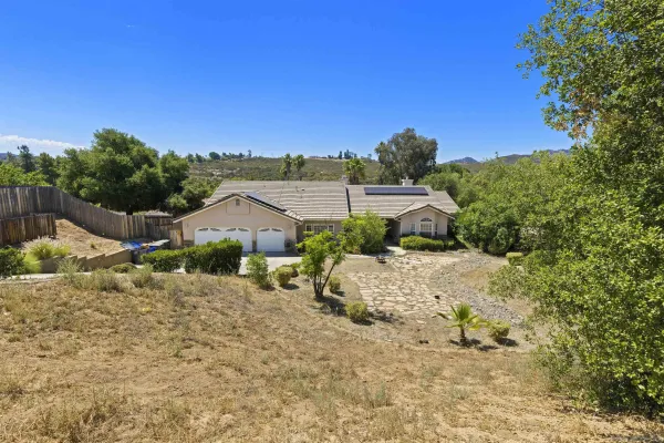 a view of a dry yard with wooden fence