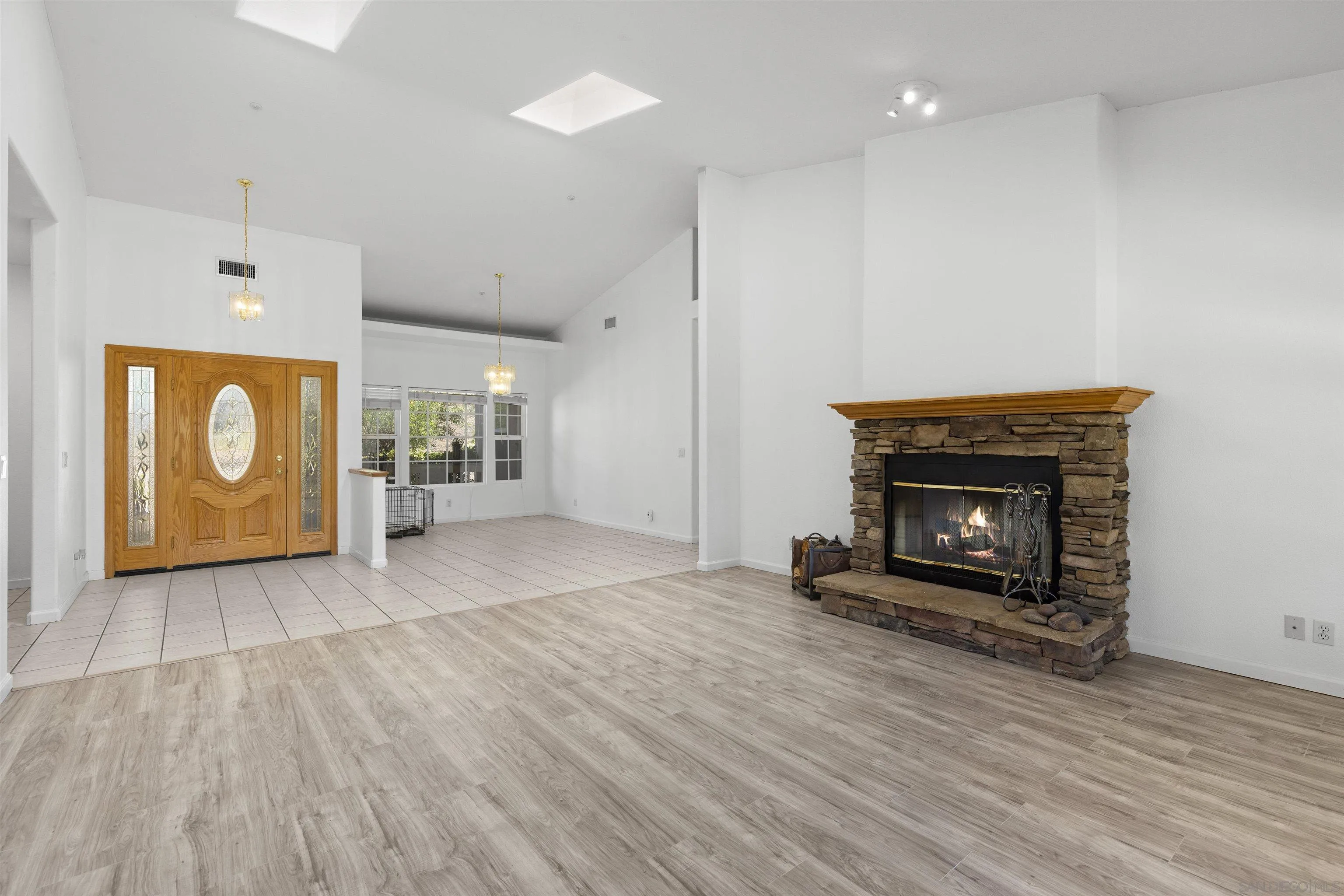 24849 Pappas Road Ramona, CA 92065 - Photo 5 of 50 an empty room with wooden floor fire place and windows