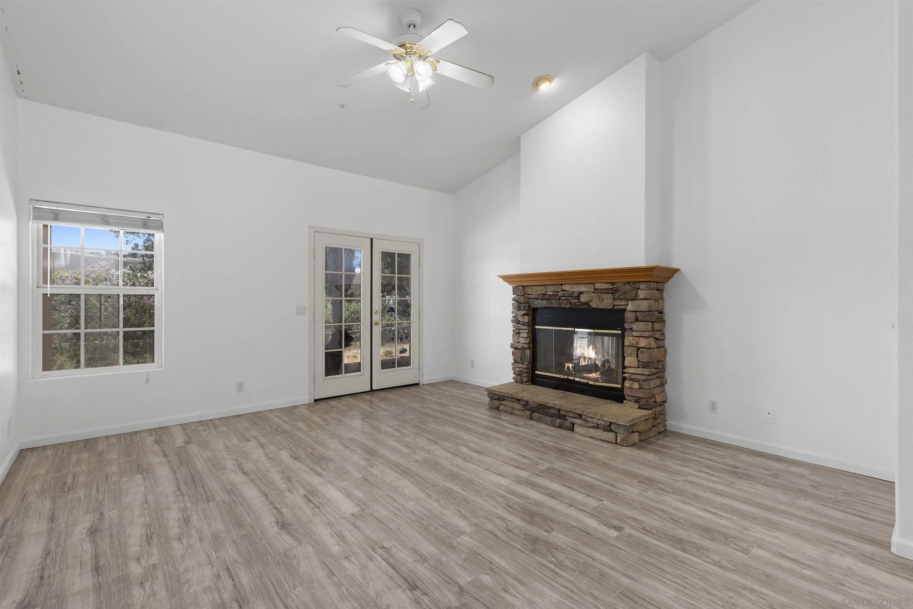 24849 Pappas Road Ramona, CA 92065 - Photo 7 of 50 a view of an empty room with wooden floor fireplace and a window