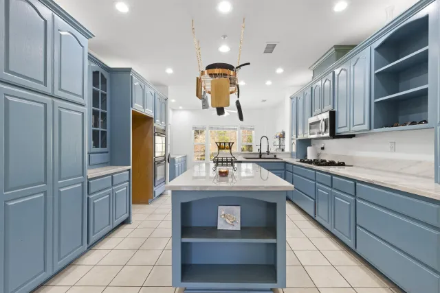 a kitchen with kitchen island granite countertop a sink and refrigerator