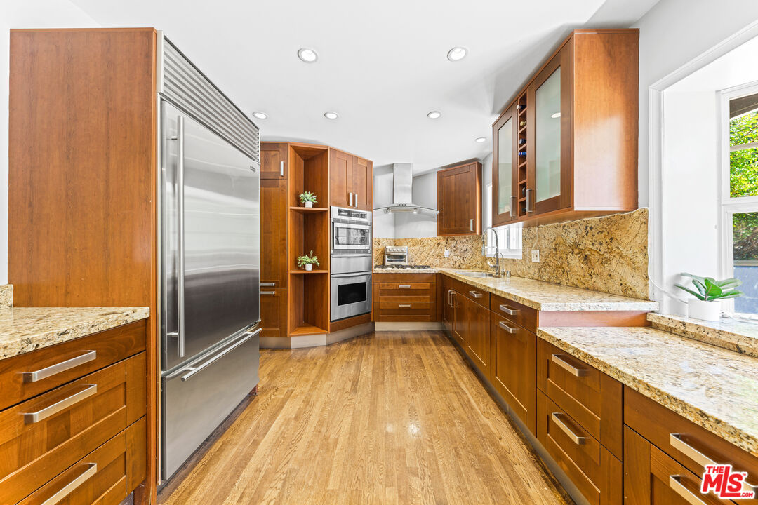 3940 Mandeville Canyon Road Los Angeles, CA 90049 - Photo 15 of 54 a large kitchen with kitchen island granite countertop a large counter top stainless steel appliances a sink and cabinets