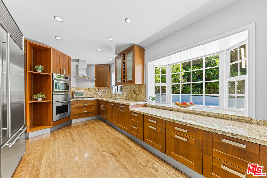 3940 Mandeville Canyon Road Los Angeles, CA 90049 - Photo 16 of 54 a kitchen with stainless steel appliances granite countertop a stove and a sink