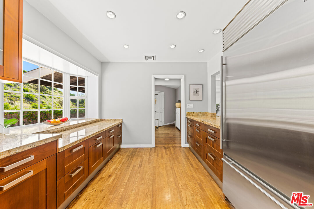 3940 Mandeville Canyon Road Los Angeles, CA 90049 - Photo 17 of 54 a spacious bathroom with a granite countertop sink and a refrigerator