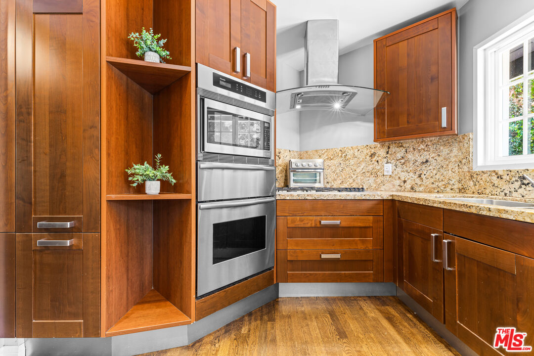 3940 Mandeville Canyon Road Los Angeles, CA 90049 - Photo 18 of 54 a bathroom with a granite countertop sink and a mirror