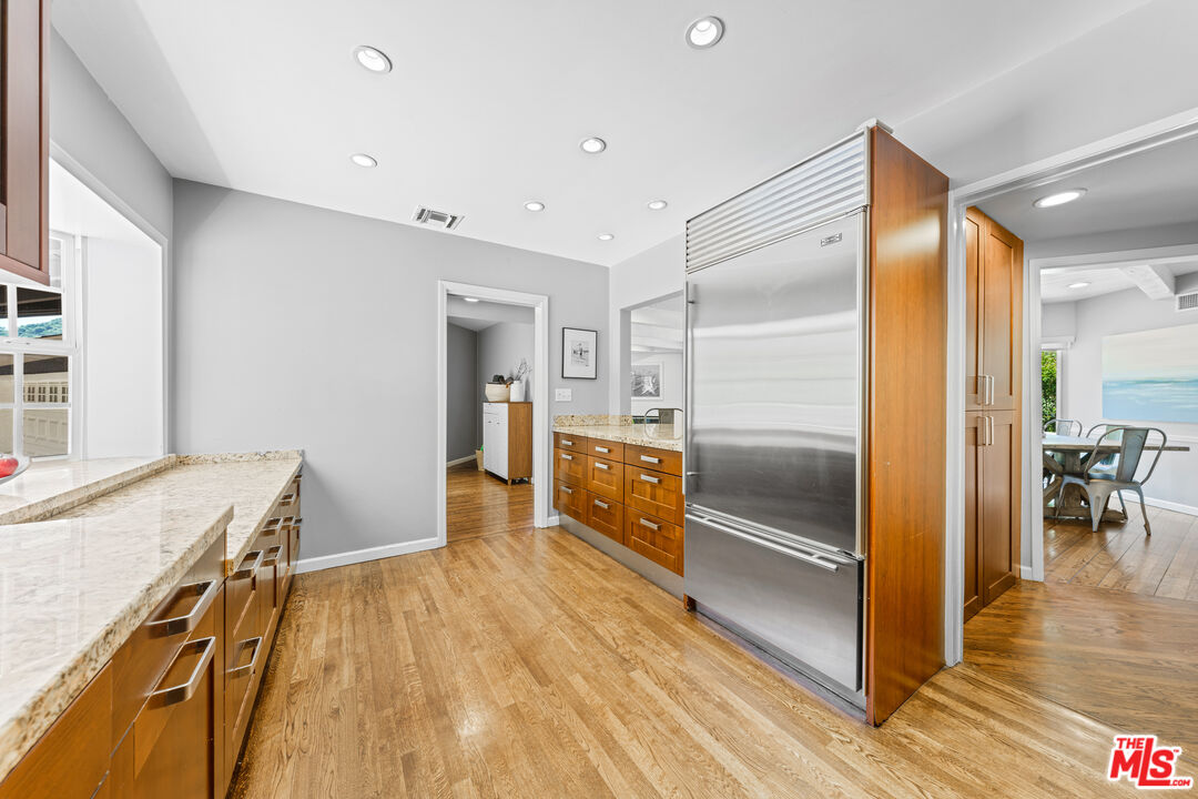 3940 Mandeville Canyon Road Los Angeles, CA 90049 - Photo 19 of 54 a kitchen with granite countertop a refrigerator and a sink