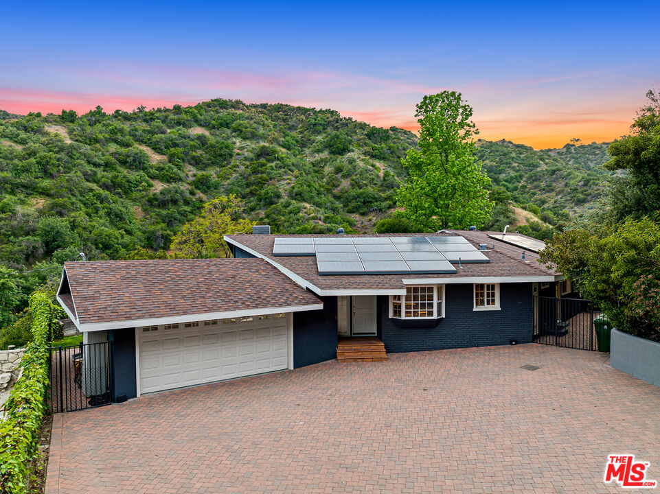 3940 Mandeville Canyon Road Los Angeles, CA 90049 - Photo 2 of 54 a house with trees in the background