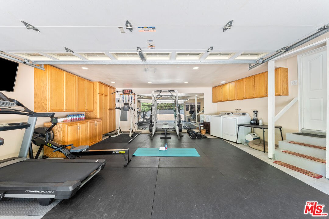 3940 Mandeville Canyon Road Los Angeles, CA 90049 - Photo 21 of 54 a room with gym equipment and large windows