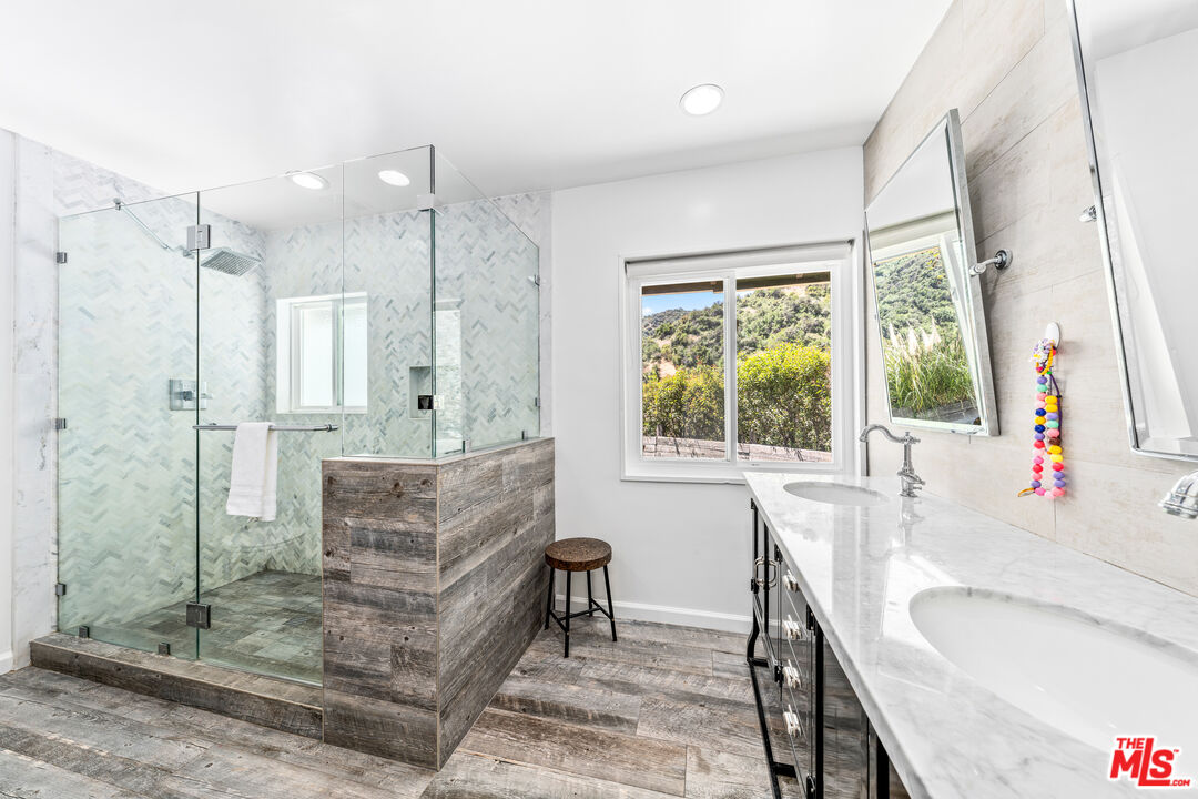 3940 Mandeville Canyon Road Los Angeles, CA 90049 - Photo 26 of 54 a bathroom with a granite countertop sink mirror and a bathtub