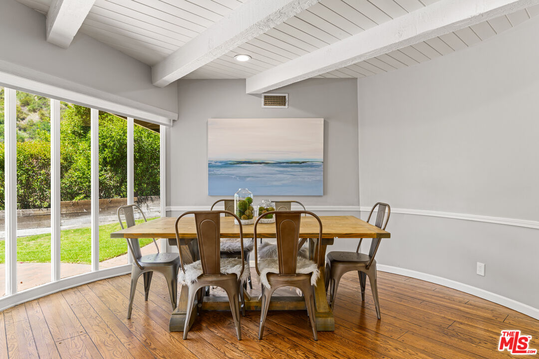 3940 Mandeville Canyon Road Los Angeles, CA 90049 - Photo 40 of 54 a view of a dining room with furniture and wooden floor