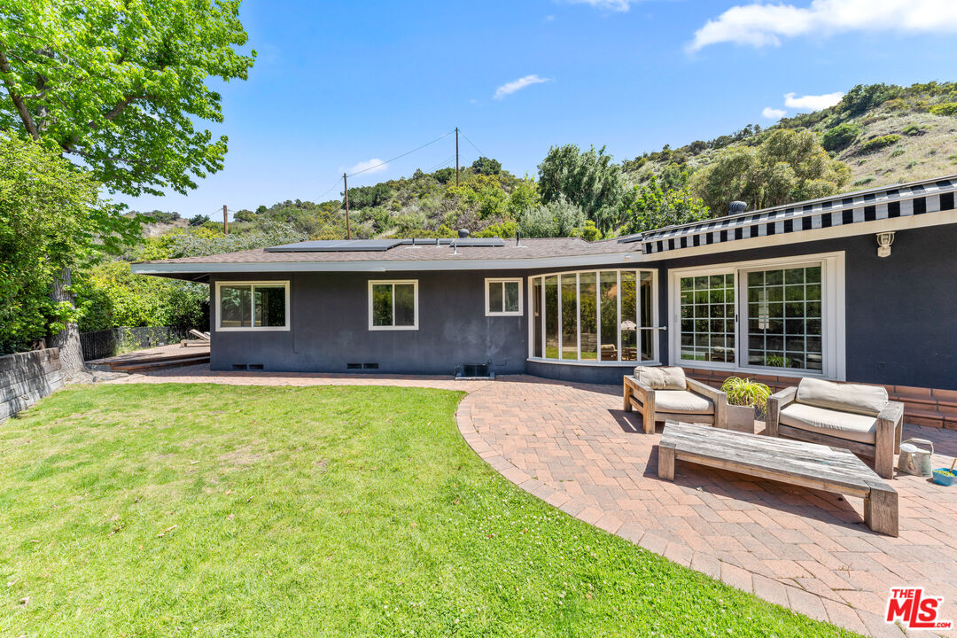 3940 Mandeville Canyon Road Los Angeles, CA 90049 - Photo 46 of 54 a house view with a sitting space and garden