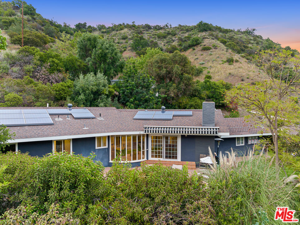 3940 Mandeville Canyon Road Los Angeles, CA 90049 - Photo 50 of 54 front view of a house with a yard